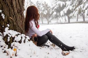 bella giovane donna nel inverno parco, rosso dai capelli ragazza nel il parco nel inverno foto