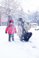 madre e il poco ragazzo siamo giocando nel inverno parco, madre e carino ragazzo foto