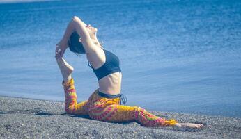 persona fare yoga esercizio su il spiaggia, persona rilassante su il spiaggia, personn fare yoga foto