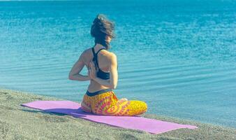 persona fare yoga esercizio su il spiaggia, persona rilassante su il spiaggia, personn fare yoga foto