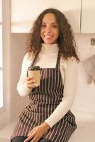 donna latina che beve caffè in cucina