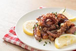 polpo o calamari alla griglia con salsa di burro al limone foto