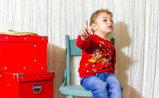 il poco bambino giocando con Natale decorazioni nel studio, poco bambino con Natale palla foto