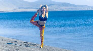 persona fare yoga esercizio su il spiaggia, persona rilassante su il spiaggia, personn fare yoga foto