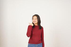 giovane asiatico donna nel rosso maglietta puntamento lato a copia spazio con pollice isolato su bianca sfondo foto