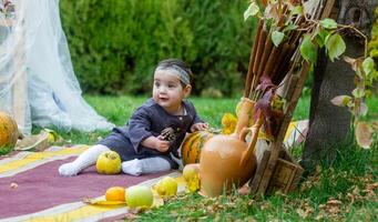 il poco bambino giocando nel il parco con frutta, poco ragazza nel il autunno parco foto