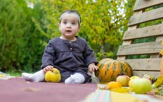 il poco bambino giocando nel il parco con frutta, poco ragazza nel il autunno parco foto