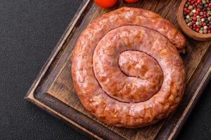 delizioso grigliato salsiccia nel il modulo di un' squillare con sale, spezie e erbe aromatiche foto