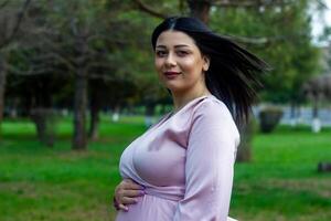il incinta donna nel il parco, bellissimo donna nel il parco, incinta donna nel primavera foto