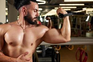 bodybuilder formazione il suo muscoli nel palestra, bodybuilder formazione con manubrio foto