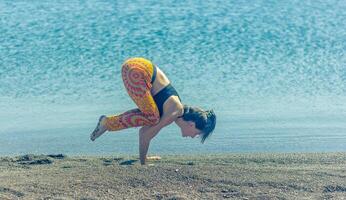 persona fare yoga esercizio su il spiaggia, persona rilassante su il spiaggia, personn fare yoga foto