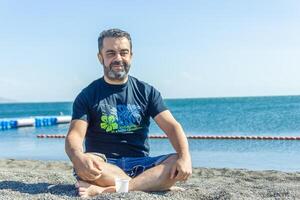 persona fare yoga esercizio su il spiaggia, persona rilassante su il spiaggia, personn fare yoga foto