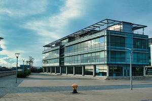 moderno ufficio edificio con bicchiere facciata su un' chiaro giorno, urbano aziendale architettura. foto