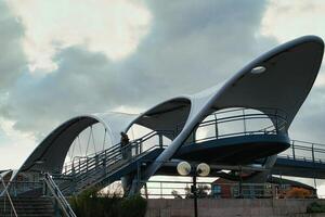 moderno pedone ponte con unico architettura contro un' nuvoloso cielo. foto