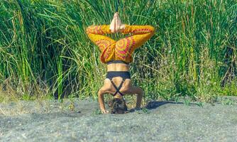 persona fare yoga esercizio su il spiaggia, persona rilassante su il spiaggia, personn fare yoga foto