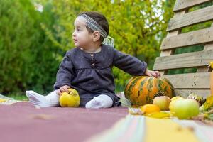 il poco bambino giocando nel il parco con frutta, poco ragazza nel il autunno parco foto