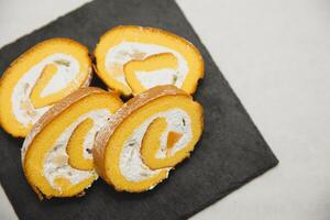 affettato svizzero rotolo torta con crema formaggio su bianca sfondo foto