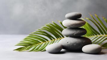 ai generato zen pietre e palma foglia su grigio sfondo, terme e benessere concetto foto
