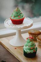 cupcakes con verde crema e spruzzatori su un' bianca In piedi foto