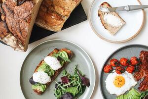 salutare prima colazione con uova, avocado, pane e crostini su bianca sfondo foto