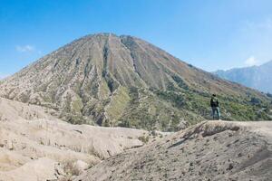 turista in piedi a il cresta nel davanti di montare Batok vulcano nel bromo Tengger Semeru nazionale parco nel est Giava, Indonesia. foto