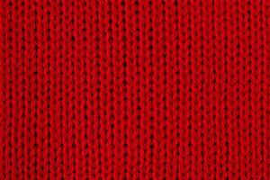 rosso a maglia tessuto macro foto. dettaglio di Abiti come un' rosso sfondo. foto