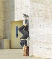 giovane ragazza fare esercizio nel il città, donna fare yoga esercizio, persona fare allungamento, donna rilassante nel il città, bella ragazza fare fitness esercizio foto