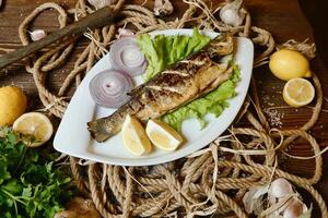 bianca piatto con pesce, limoni, e cipolle foto