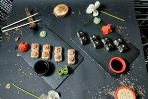 Sushi e bastoncini disposte su tavolo foto