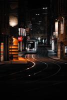 verticale foto fotografia di tram nel città luci a notte con giallo luci