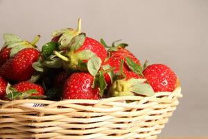 un' cestino di fragole su un' di legno tagliare tavola su bianca sfondo foto