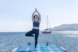 persona fare yoga esercizio su il spiaggia, persona rilassante su il spiaggia, personn fare yoga foto