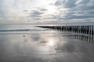 nord mare costa, cupo tramonto dietro a pioggia nuvole foto