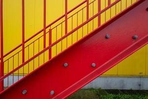 rosso fuga scala al di fuori scala su giallo parete industriale edificio foto