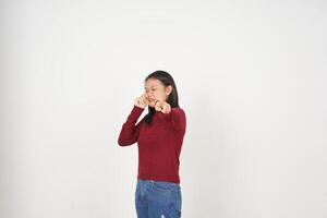 giovane asiatico donna nel rosso maglietta triste pianto e puntamento a telecamera isolato su bianca sfondo foto