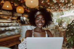 ai generato giovane nero donna Lavorando su il computer portatile nel accogliente bar, sorridente foto