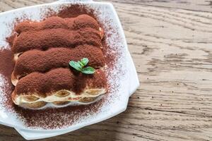 Tiramisù su il piatto su il di legno sfondo foto