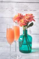 Due bicchieri di bellini cocktail con mazzo di Rose foto