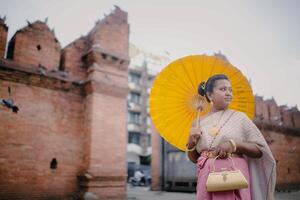 ragazza nel tailandese costume a tha fa cancello vecchio città nel chiang Mai Tailandia foto