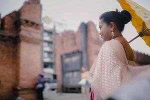 ragazza nel tailandese costume a tha fa cancello vecchio città nel chiang Mai Tailandia foto