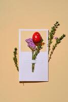 Pasqua carta con un' rosso Quaglia uovo su un' beige sfondo. foto