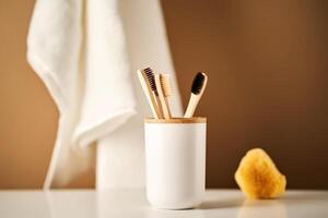 bambù spazzolini da denti nel un' tazza e un' asciugamano nel un' bagno interno. foto