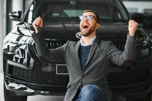 contento proprietario di un' nuovo macchina. emotivo bello uomo nel casuale Abiti è felice, acquisto un' auto nel il concessionaria. foto