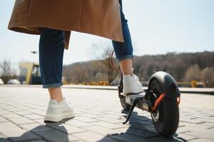 ritagliata su donna gambe piedi equitazione su elettrico calcio scooter nel città foto