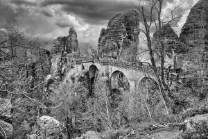 il bastei ponte nel sassone Svizzera nel nero e bianca. frastagliato rocce. turista foto