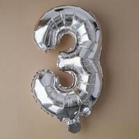 3 tre metallico Palloncino su beige neutro sfondo. saluto carta argento Foglio Palloncino numero contento compleanno vacanza concetto. copia spazio per testo. celebrazione festa congratulazione decorazione foto