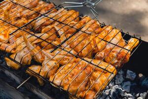 delizioso pollo frittura su barbecue griglia grattugiare all'aperto. stagionatura caduta su fresco grigliato pollo Ali. estate festa cibo idee. bbq succoso torrefazione pollo griglia gambe su griglia grattugiare foto