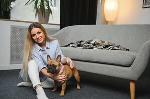 giovane donna con sua carino cane a casa. bello animale domestico foto