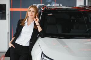 giovane bellissimo donna mostrando sua amore per un' auto nel un' auto showroom. foto