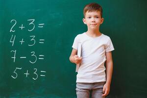 divertente scolaro vicino il verde scuola tavola nel il aula. elementare scuola. indietro per scuola. foto